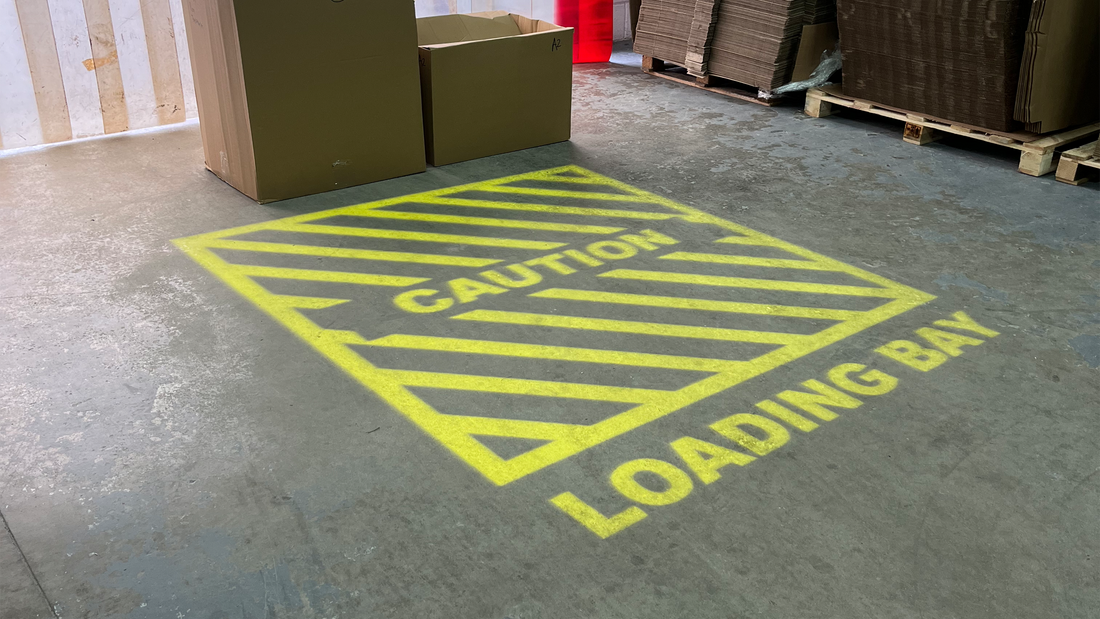 Yellow projected sign of a loading bay in a UK warehouse.