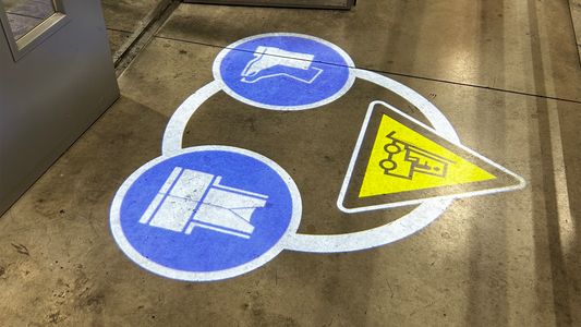 Projected floor marking on a warehouse floor to improve forklift safety and PPE requirements.